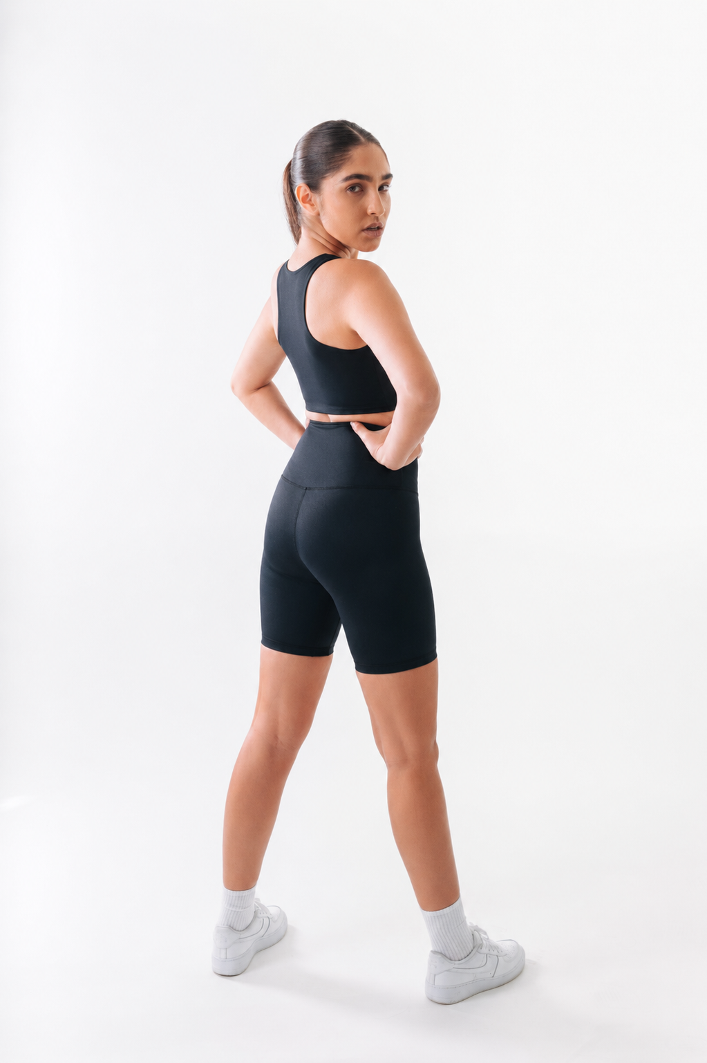 Woman wearing a black athletic outfit on a white background