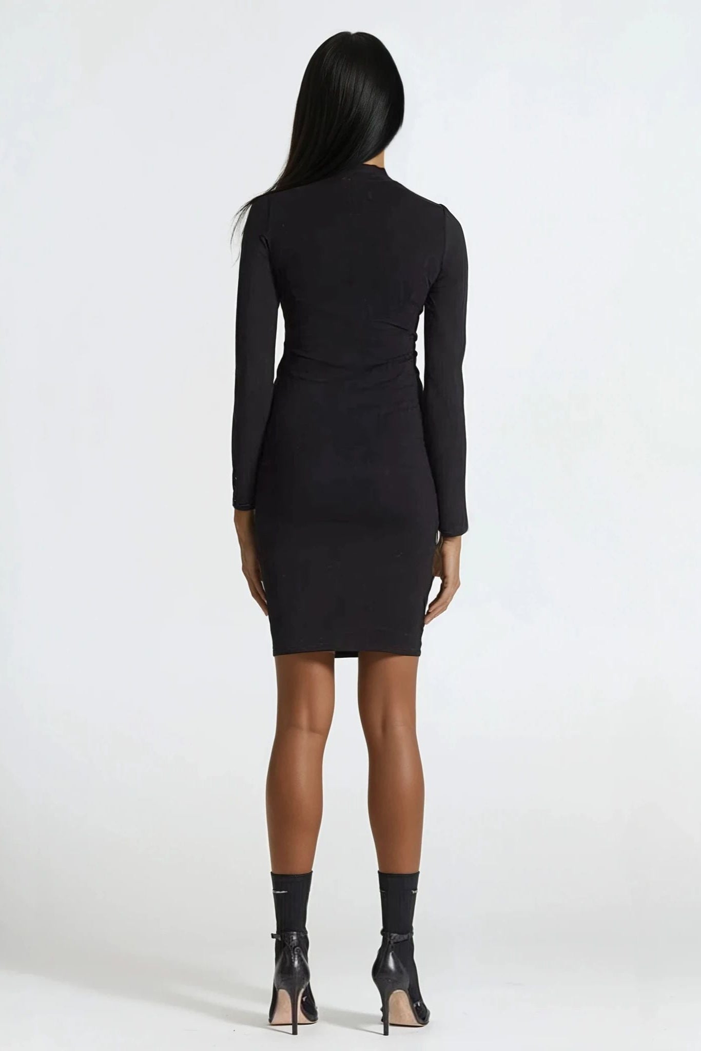 Black dress worn by a model on a white background