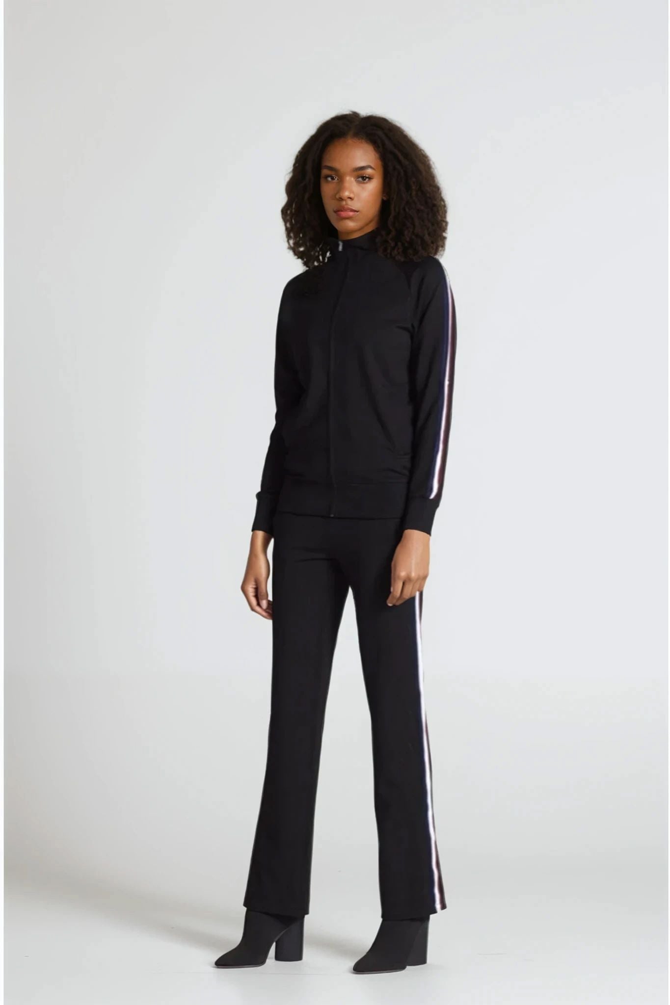 Person wearing a black outfit with white stripes on a white background