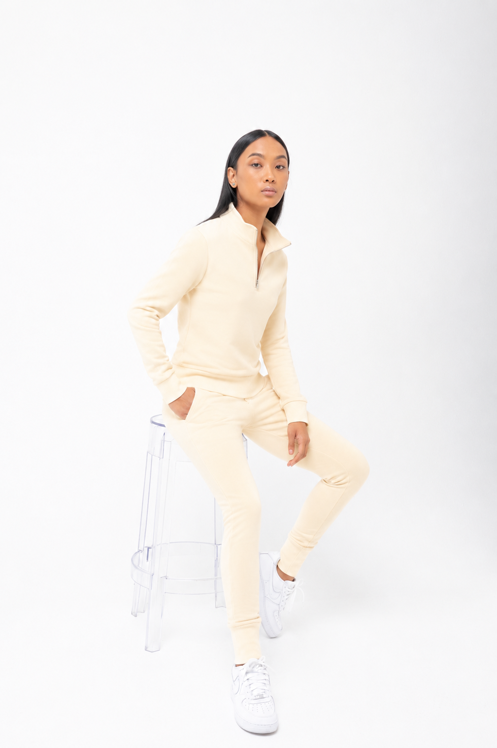 Person wearing a light yellow tracksuit on a white background