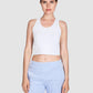 Woman wearing a white tank top and light blue shorts on a white background