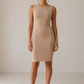 Women in tank dress against beige wall