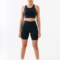 Woman wearing a black athletic outfit on a white background