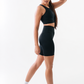 Woman wearing a black athletic outfit on a white background