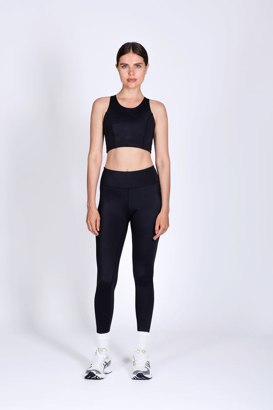 Person wearing a black athletic outfit on a white background