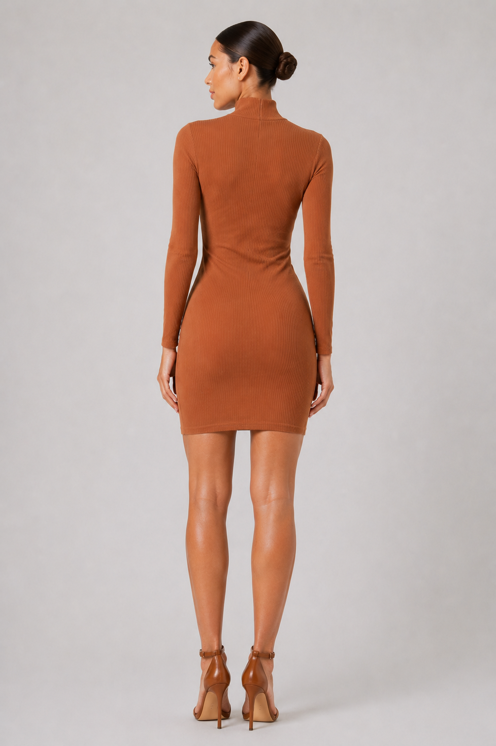 Woman wearing a brown dress on a plain background