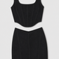 Black sleeveless top and pencil skirt set on a light gray background