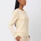 Woman wearing a cream-colored outfit against a white background