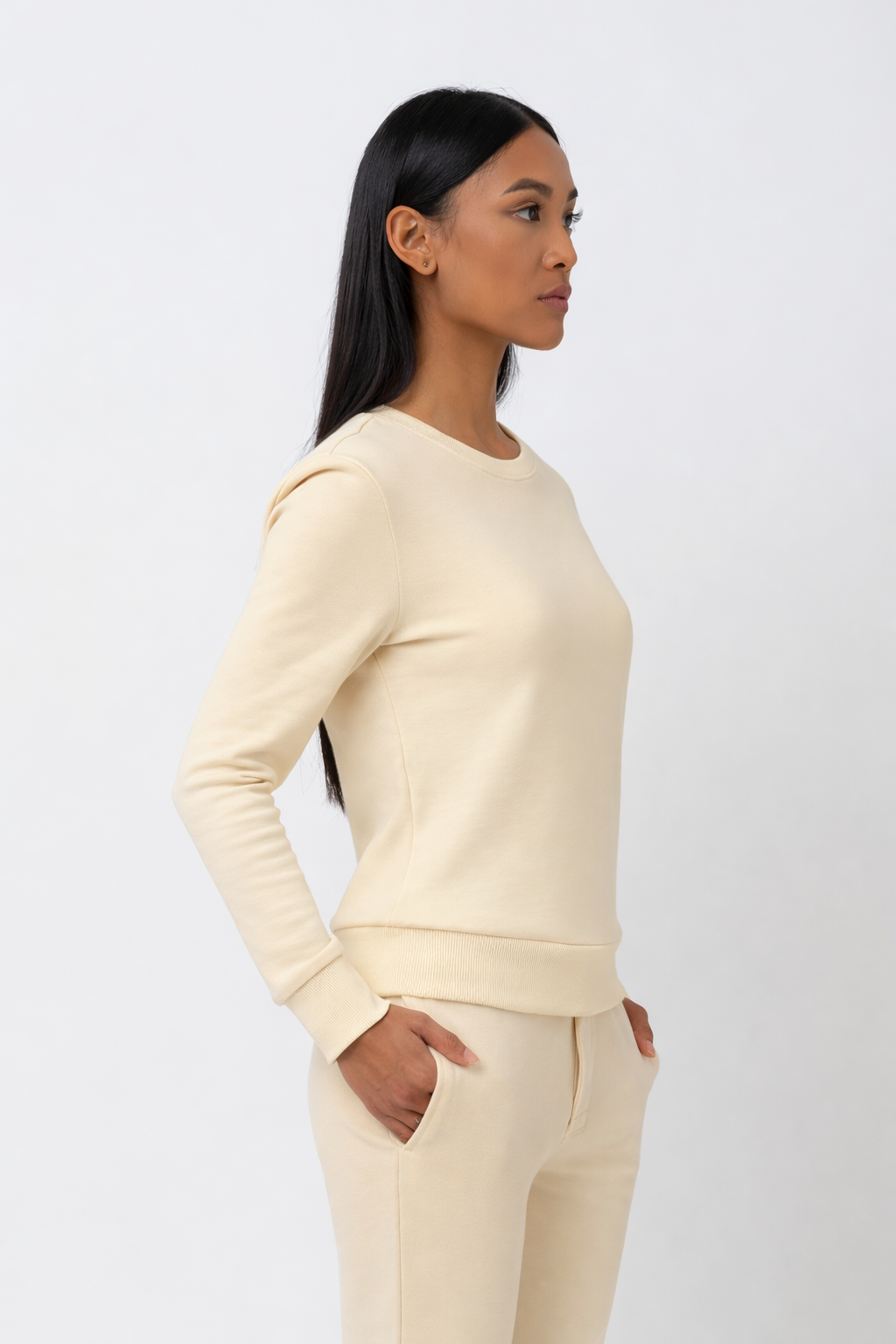 Woman wearing a cream-colored outfit against a white background