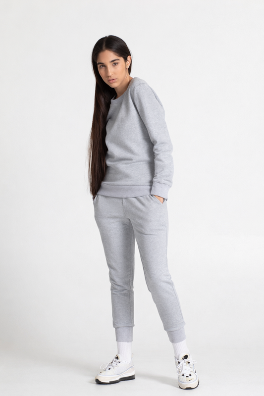 Woman wearing a gray tracksuit on a white background