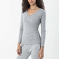 Woman wearing a gray long-sleeve top and pants on a white background