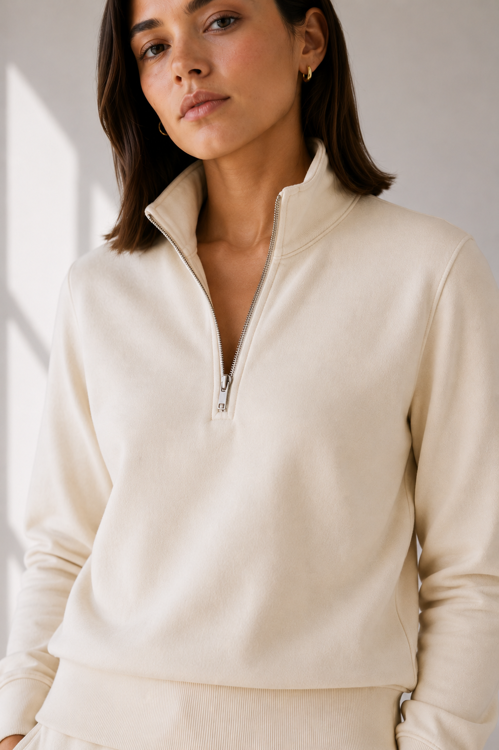 Close up view of model in cream sweatshirt.