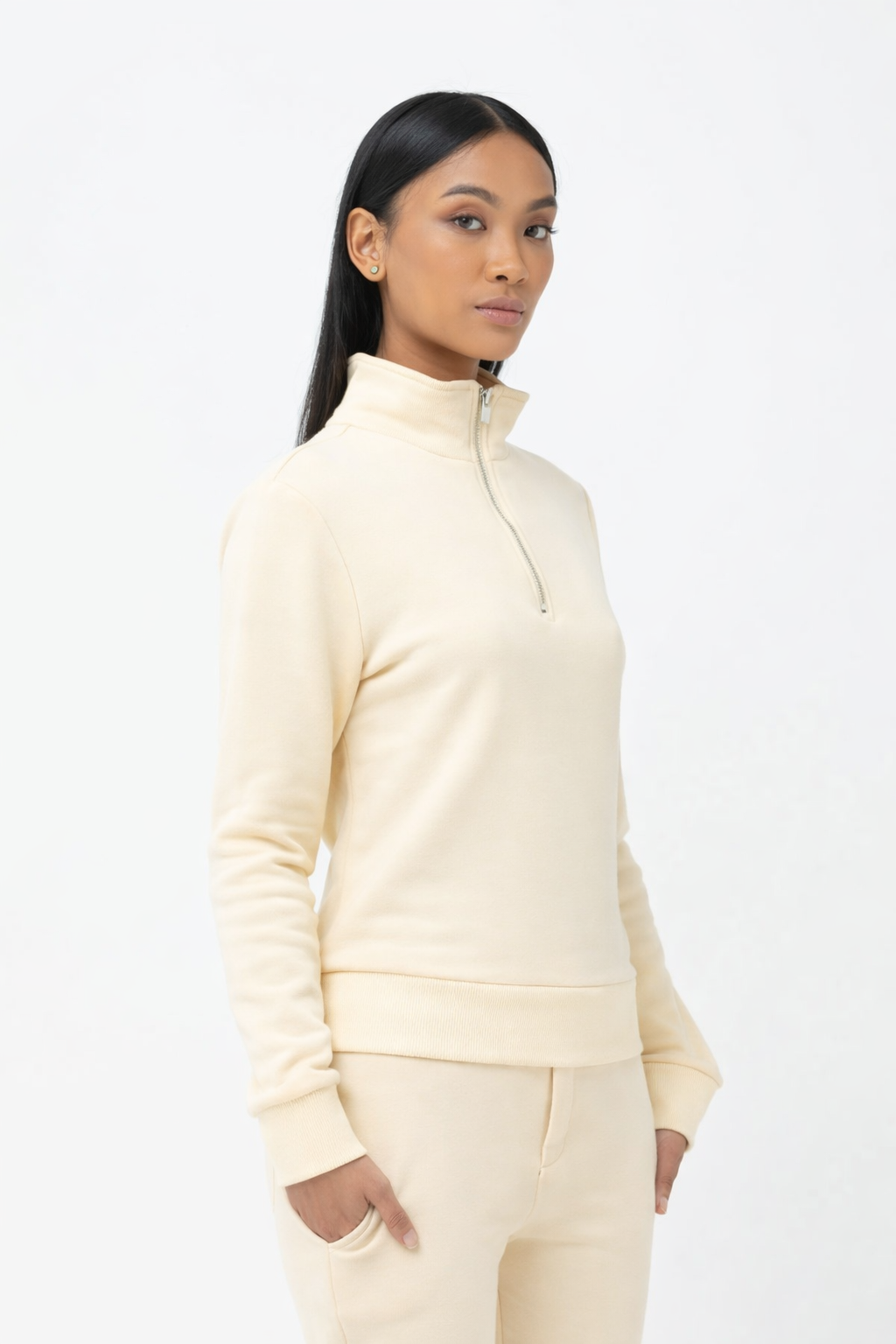 Woman wearing a cream-colored outfit on a white background