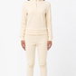 Person wearing a cream-colored tracksuit on a white background