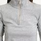 Close up shot of model in half zip top against white background.