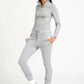 A model wearing a gray half zip top with a silver zip fastening, paired with matching pants and white sneakers.