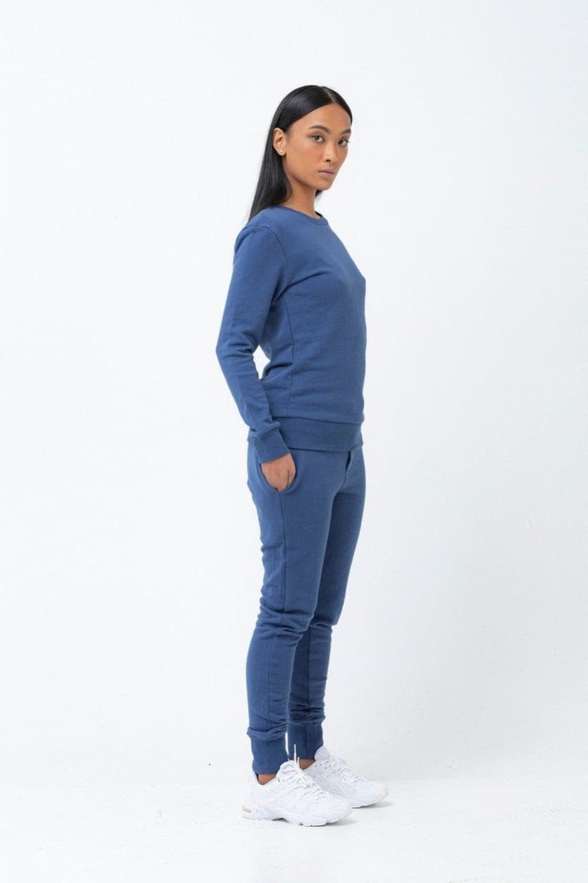 Model in indigo blue cotton sweatpants with matching sweatshirt