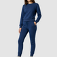 Woman wearing a blue tracksuit on a gray background