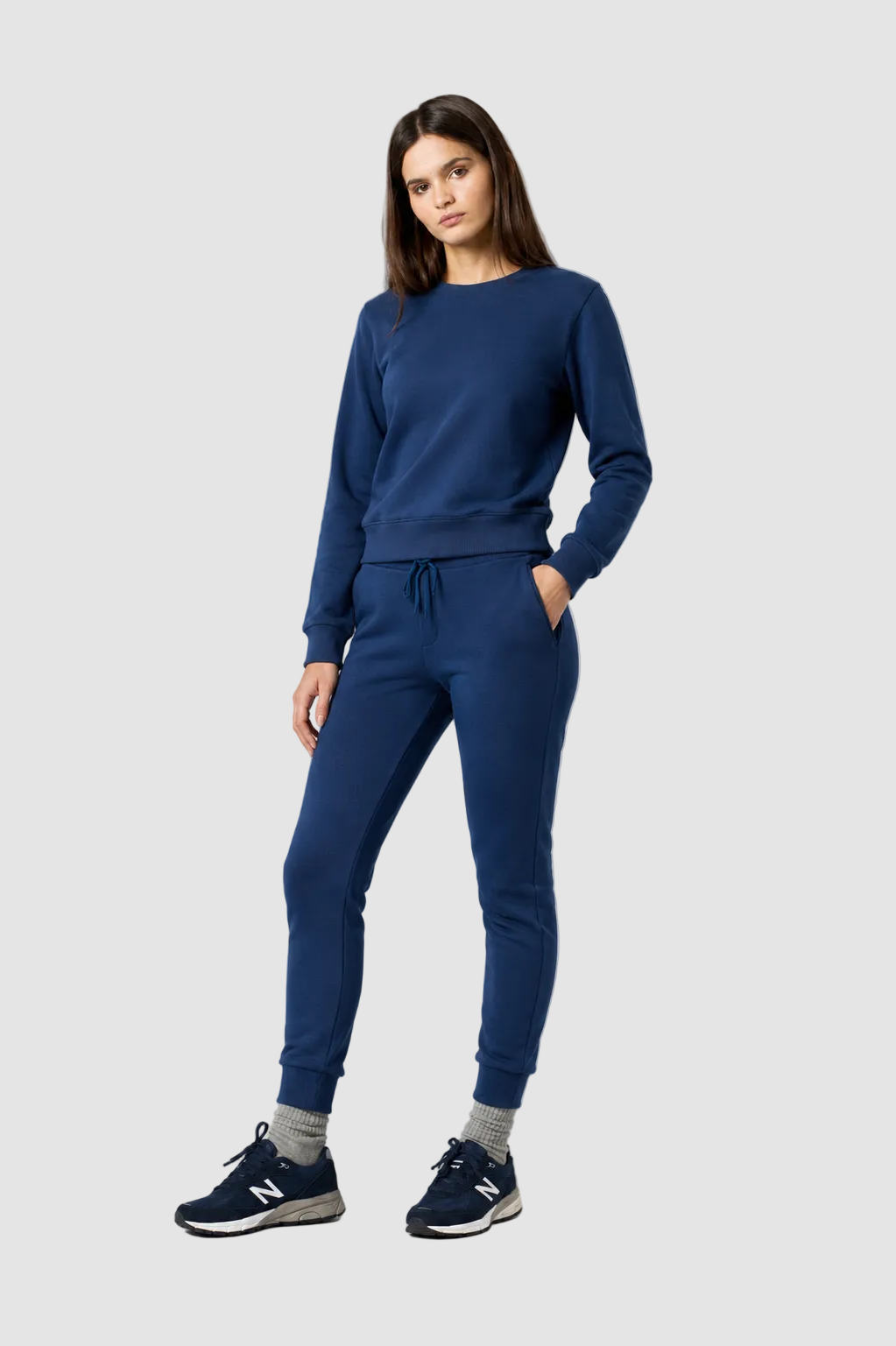 Woman wearing a blue tracksuit on a gray background