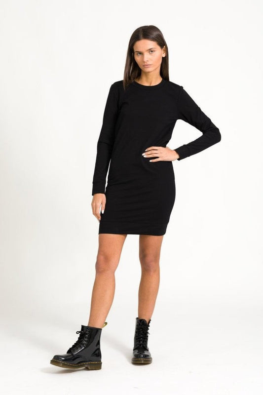A model wearing a black dress with long sleeves and a crew neckline.