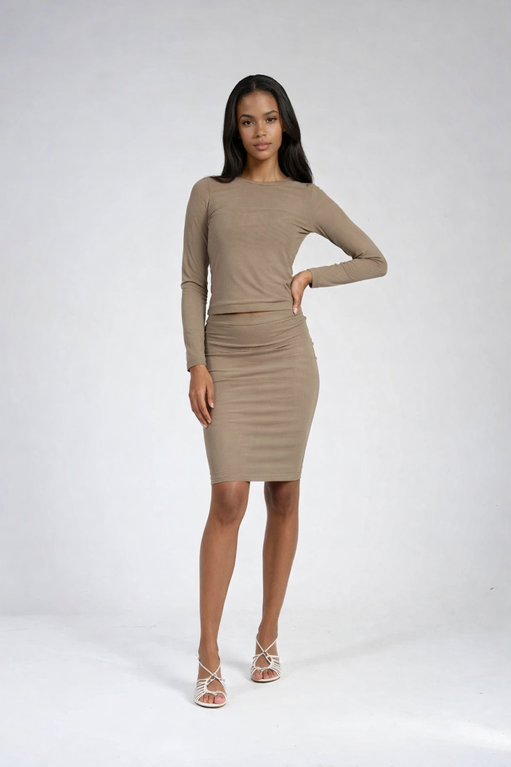 Woman wearing a beige long-sleeve dress on a white background