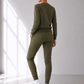 Person wearing an olive green tracksuit standing in a well-lit room with a window.