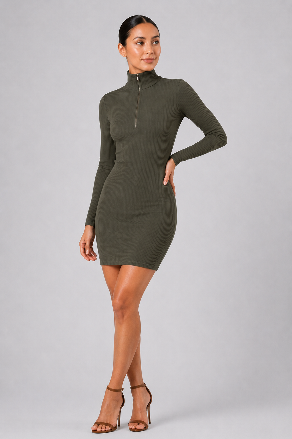 Woman wearing a green dress with a zipper on a gray background