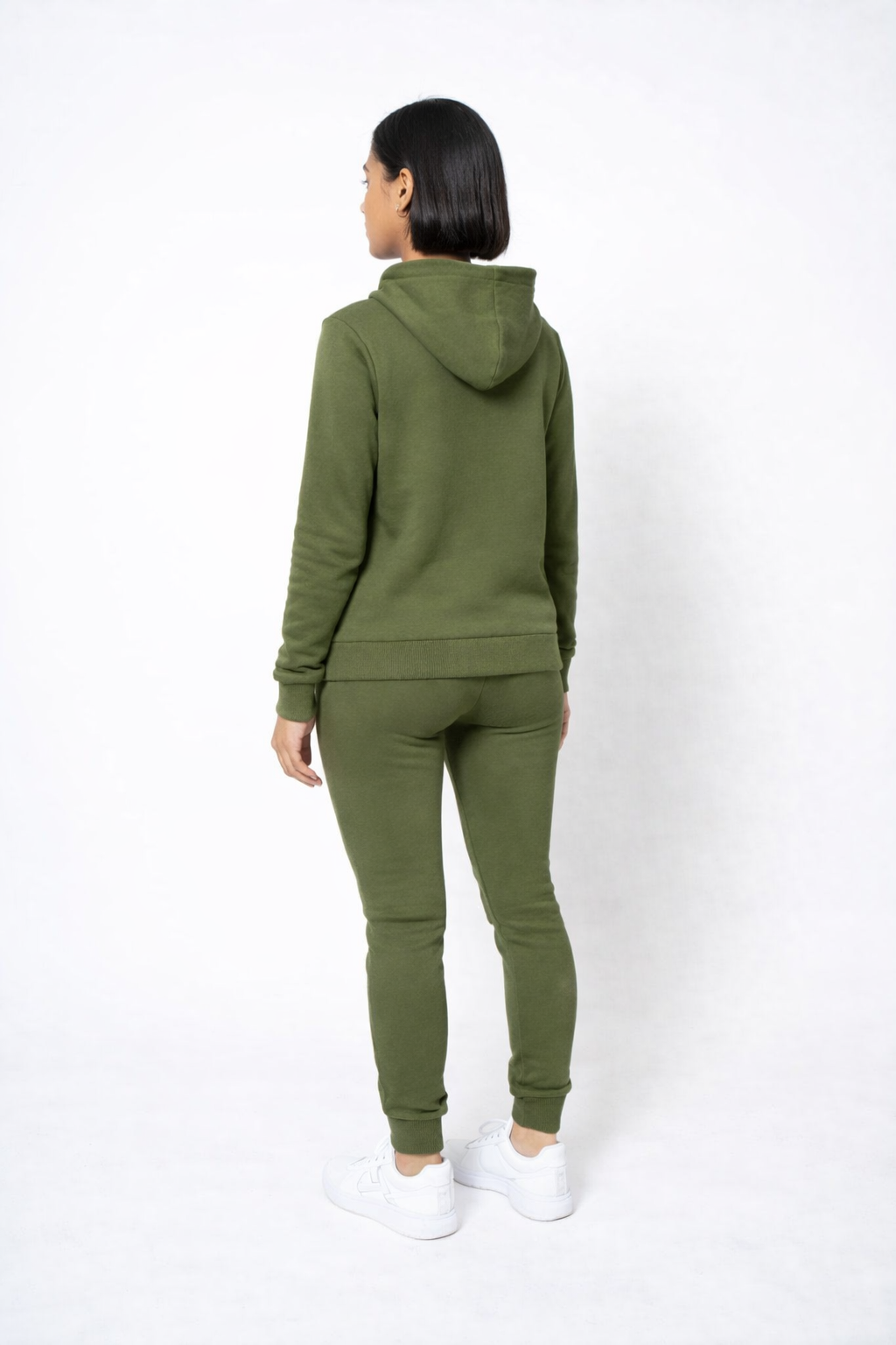 Person wearing a green tracksuit on a white background