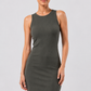 Woman wearing a sleeveless green dress against a plain background