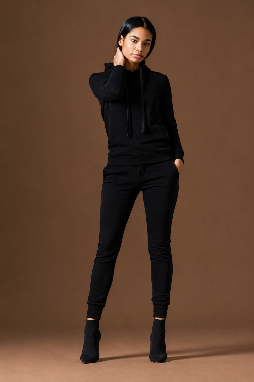 Woman wearing a black outfit against a brown background