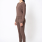 Woman wearing a brown outfit standing against a white background