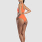 Woman wearing an orange bikini set on a white background