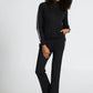 Woman wearing a black outfit with white stripes on a white background