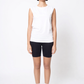 Person wearing a white sleeveless top and black shorts on a white background