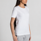A woman wearing a plain white short-sleeve crewneck t-shirt and light gray sweatpants, standing against a light gray studio background.