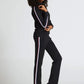 Woman wearing a black outfit with white stripes on a white background