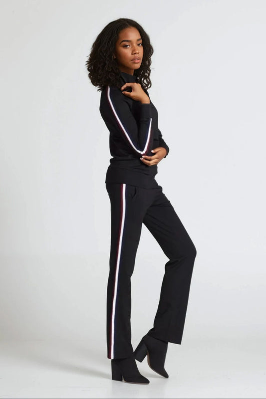 Woman wearing a black outfit with white stripes on a white background