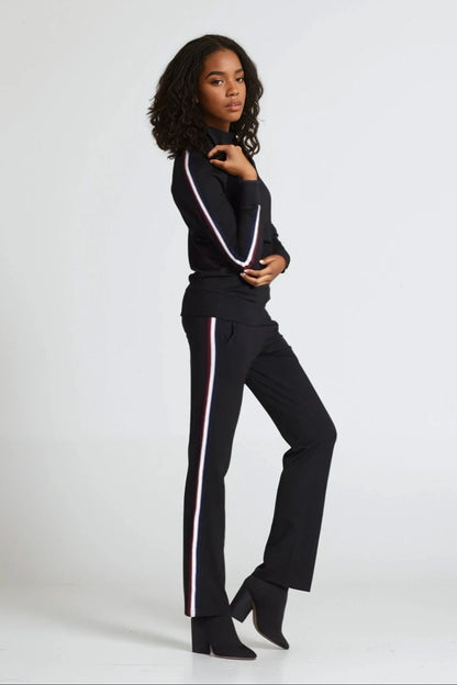 Woman wearing a black outfit with white stripes on a white background