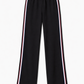 Black pants with a button detail on a white background
