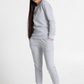 Woman wearing a grey sweatshirt and sweatpant on a white background