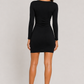 Woman wearing a black dress on a plain background
