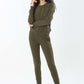 Woman wearing an olive green tracksuit on a white background