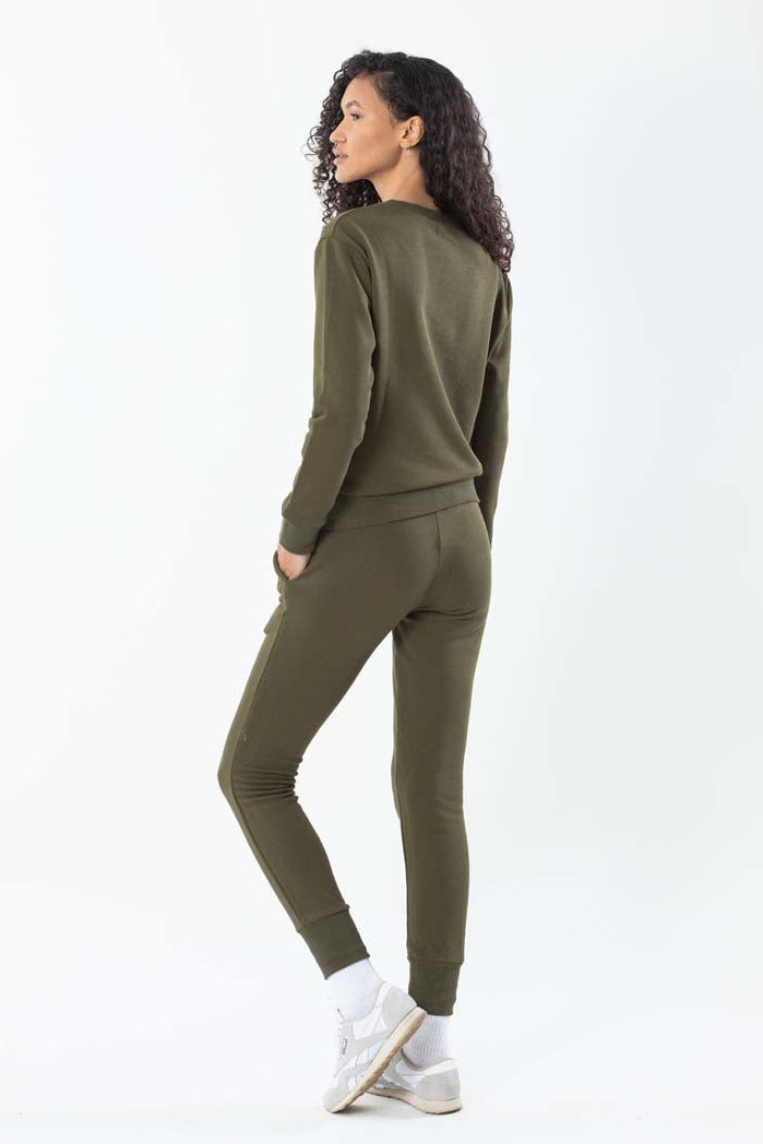 Woman wearing an olive green outfit on a white background