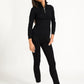 Model in black zip top outfit against a white background.